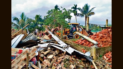 A bulldozer razes a house in Nagaon, Assam, on Sunday. (ANI)
