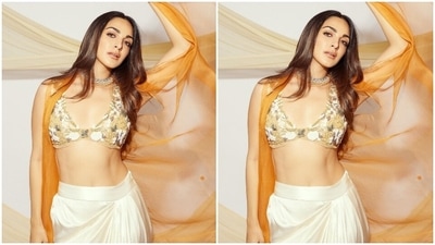 Kiara paired the yellow bralette top with a satin silk skirt in a pristine pearl white shade. It features a knee-high slit on the front, floor-grazing hem and layered pleats. A see-through zari cape in an orange hue and draped on Kiara's shoulders with dainty sequin embroidery rounded off the outfit. (Instagram) Kiara paired the yellow bralette top with a satin silk skirt in a pristine pearl white shade. It features a knee-high slit on the front, floor-grazing hem and layered pleats. A see-through zari cape in an orange hue and draped on Kiara's shoulders with dainty sequin embroidery rounded off the outfit. (Instagram)