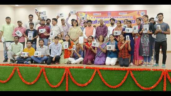 Students pose with their newly acquired smart phones and tablets alongside UP cabinet minister Nand Gopal Gupta and UPRTOU V-C Prof Seema Singh on Sunday. (HT Photo)