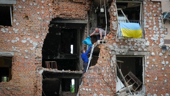 Residents take out their belongings from their house ruined by the Russian shelling in Irpin close to Kyiv, Ukraine.(AP)