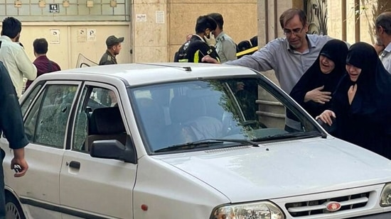 Women mourning next to the body of Iranian Revolutionary Guards colonel Sayyad Khodai, after he was shot dead, in his car in the Iranian capital Tehran.(AFP)