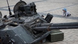 A child looks at a destroyed Russian infantry fighting vehicle during an exhibition displaying destroyed Russian military vehicles, amid Russia's invasion, in central Kyiv, Ukraine.