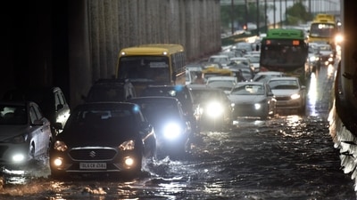 Commuters wade through a waterlogged stretch in Noida on Monday. (Sunil Ghosh / HT Photo). Commuters wade through a waterlogged stretch in Noida on Monday. (Sunil Ghosh / HT Photo).