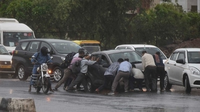Locals try to help a car wade through a waterlogged stretch in Gurugram on Monday. (Vipin Kumar/ HT Photo) Locals try to help a car wade through a waterlogged stretch in Gurugram on Monday. (Vipin Kumar/ HT Photo)