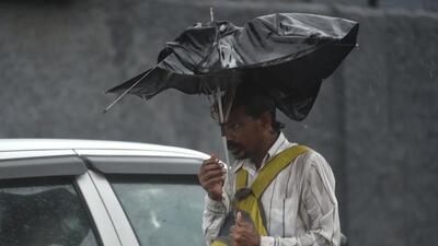 A commuter protects himself from gusty winds and heavy rainfall in Delhi NCR on Monday. (PTI Photo) A commuter protects himself from gusty winds and heavy rainfall in Delhi NCR on Monday. (PTI Photo)