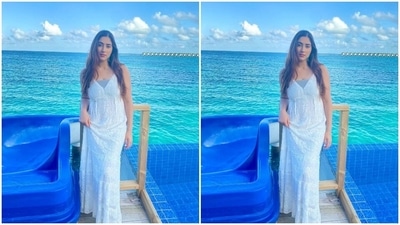 Disha posted the photos of herself dressed in the white georgette maxi dress with the caption, "Sea Angel." Her ensemble is from the shelves of the luxe boho clothing label Loca Bonita. She teamed it with minimal accessories, including hoop earrings embellished with emerald stones, white acrylic nail paint and white slip-on sandals. (Instagram) Disha posted the photos of herself dressed in the white georgette maxi dress with the caption, "Sea Angel." Her ensemble is from the shelves of the luxe boho clothing label Loca Bonita. She teamed it with minimal accessories, including hoop earrings embellished with emerald stones, white acrylic nail paint and white slip-on sandals. (Instagram)