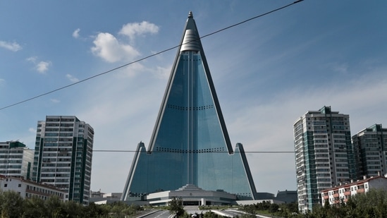 &nbsp;A traffic officer is dwarfed by the 105-story Ryugyong Hotel in Pyongyang, North Korea, Wednesday, Sept. 11, 2019. U.S. President Joe Biden met Monday while visiting Japan with families of citizens abducted by North Korea decades ago to show his support for their efforts to win the return of their loved ones.(AP)