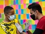 Dr. Mayank Amin administers a Pfizer-BioNTech Covid-19 booster vaccine to 10-year-old Ernest "EJ" Jones in Schwenksville, Pennsylvania.