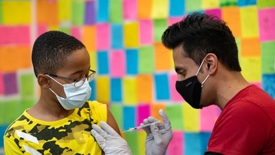 Dr. Mayank Amin administers a Pfizer-BioNTech Covid-19 booster vaccine to 10-year-old Ernest "EJ" Jones in Schwenksville, Pennsylvania. (Reuters / File)