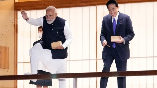 Prime Minister Narendra Modi and his Japanese counterpart Fumio Kishida feed carp before their dinner at Akasaka Palace state guest house in Tokyo on Tuesday, (AP)