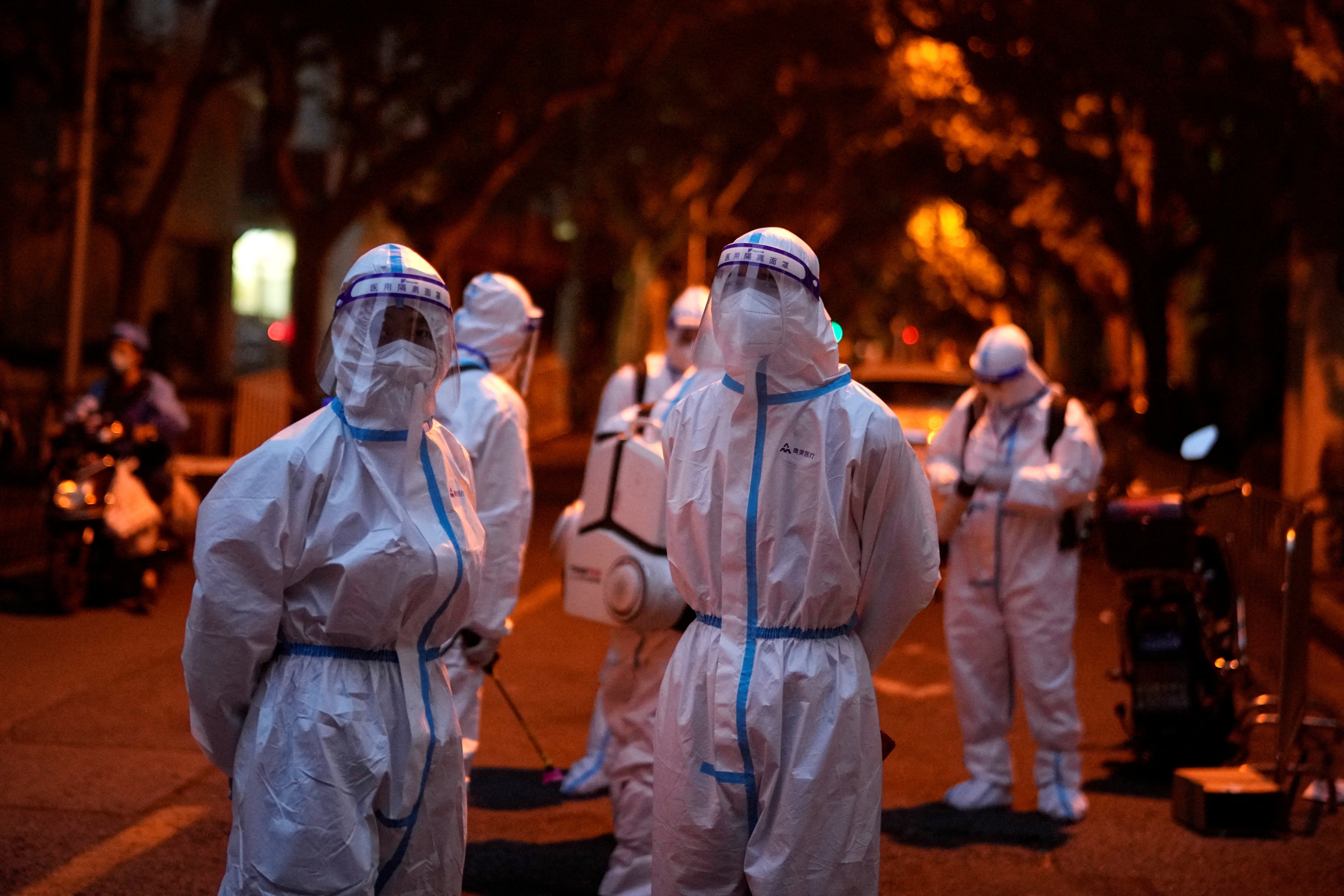 Workers in protective suits stand at a closed residential area during lockdown, amid the coronavirus disease (COVID-19) outbreak, in Shanghai, China, May 23, 2022. REUTERS/Aly Song (REUTERS)