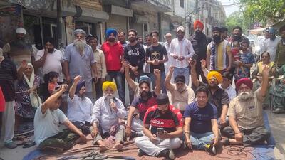 Residents and shopkeepers of Khud Mohalla area, Ludhiana, block the main road during the protest against installation of mobile tower. (Harvinder Singh/HT)
