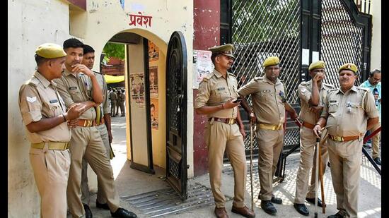 Police personnel stand guard during the hearing of the Gyanvapi Masjid-Shringar Gauri Temple case, outside the Varanasi district court, Tuesday. (PTI Photo)