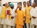 Uttar Pradesh finance Minister Suresh Khanna shows victory signs along with chief minister Yogi Adityanath as he arrives to present the State Budget 2022-23 during the budget session of the state assembly, in Lucknow.&nbsp;
