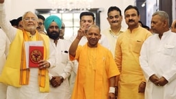 Uttar Pradesh finance Minister Suresh Khanna shows victory signs along with chief minister Yogi Adityanath as he arrives to present the State Budget 2022-23 during the budget session of the state assembly, in Lucknow.&nbsp;