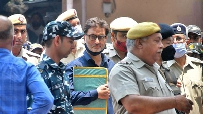 Yasin Malik, chairman of Jammu Kashmir Liberation Front (JKLF), a separatist party, is escorted by police officers at court premises. (Reuters)