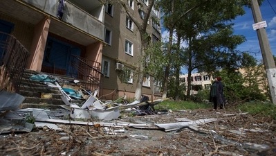 A local woman looks at an apartment building damaged by a Russian military strike, as Russia's attack on Ukraine continues, in the town of Vuhledar, in Donetsk region, Ukraine. (REUTERS)