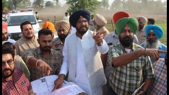 Cabinet minister Kuldeep Singh Dhaliwal (centre) at Talwandi Nauabad village in Sidhwan Bet area where 86 acres of illegally occupied government land was freed on Thursday. (HT Photo)
