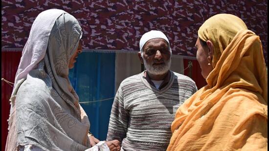 Khazir Mohammad, father of slain Kashmiri actor Amreen Bhat, with relatives during a condolence meet at Hushroo village in Budgam on Thursday. (Waseem Andrabi / HT)