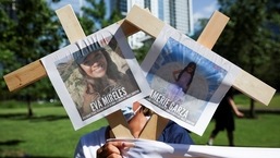 A person holds pictures of victims of the Texas shooting as they protest against gun laws outside the National Rifle Association (NRA) annual convention in Houston, Texas.