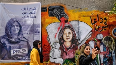 Two women take a selfie at an art exhibit honouring her late colleague Palestinian journalist Shireen Abu Akleh in Jenin city in the occupied West Bank. (AFP) Two women take a selfie at an art exhibit honouring her late colleague Palestinian journalist Shireen Abu Akleh in Jenin city in the occupied West Bank. (AFP)
