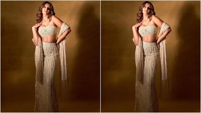 Tara paired the bralette with a matching skirt/lehenga featuring a fitted silhouette accentuating her enviable frame, mermaid-like fall, pearl and sequinned embellishments in gold, white, blue and silver shades, high-rise waistline and a floor-grazing hem. (Instagram/@tarasutaria) Tara paired the bralette with a matching skirt/lehenga featuring a fitted silhouette accentuating her enviable frame, mermaid-like fall, pearl and sequinned embellishments in gold, white, blue and silver shades, high-rise waistline and a floor-grazing hem. (Instagram/@tarasutaria)