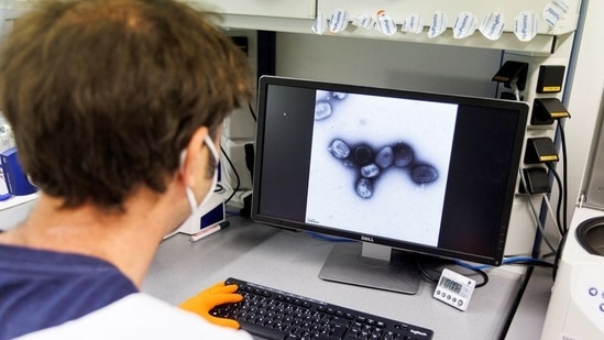 An employee of the vaccine company Bavarian Nordic shows a picture of a vaccine virus on a display in a laboratory of the company in Martinsried near Munich, Germany(REUTERS)