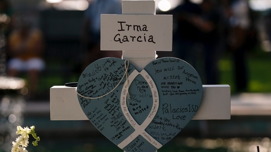 Messages are written on a cross honoring Irma Garcia, a teacher who was killed in this week's elementary school shooting, in Uvalde, Texas, on May 26, 2022. (AP) Messages are written on a cross honoring Irma Garcia, a teacher who was killed in this week's elementary school shooting, in Uvalde, Texas, on May 26, 2022. (AP)