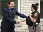 Johnny Depp shakes hands with a police officer as he departs the Fairfax County Courthouse on May 27 in Fairfax, Virginia. (AFP)(AFP) Johnny Depp shakes hands with a police officer as he departs the Fairfax County Courthouse on May 27 in Fairfax, Virginia. (AFP)(AFP)