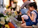 Children pray and pay their respects at a memorial site for the victims killed in this week's elementary school shooting in Uvalde, Texas, Thursday, May 26, 2022. (AP Photo/Dario Lopez-Mills)