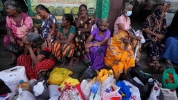 Mulheres esperam perto de um posto de combustível vazio na esperança de comprar querosene para cozinhar em Colombo, Sri Lanka.  Durante meses, os cingaleses foram forçados a fazer longas filas para comprar itens essenciais escassos, com muitos voltando para casa de mãos vazias. 