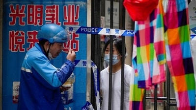 Residents chat through gaps in barriers at a closed residential area during lockdown, amid the coronavirus disease outbreak, in Shanghai, China. (REUTERS)