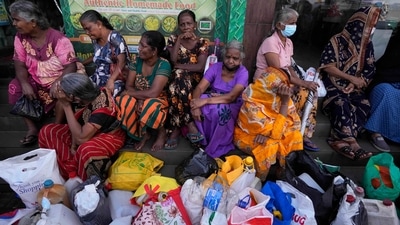 Women wait near an empty fuel station hoping to buy kerosene oil for cooking in Colombo, Sri Lanka. Sri Lankans for months have been forced to stand in long lines to buy scarce essentials, with many returning home empty-handed. (AP) Women wait near an empty fuel station hoping to buy kerosene oil for cooking in Colombo, Sri Lanka. Sri Lankans for months have been forced to stand in long lines to buy scarce essentials, with many returning home empty-handed. (AP)