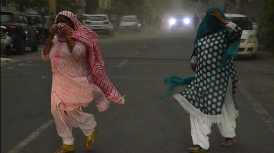 Two women caught amid strong winds witnessed in Ludhiana on Saturday. (HT Photo)