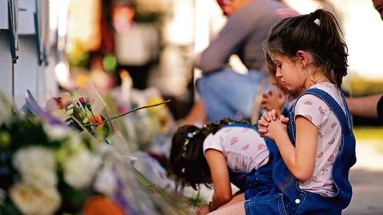 Children pray and pay their respects at a memorial site for the victims killed in this week's elementary school shooting in Uvalde, Texas, Thursday, May 26, 2022. (AP Photo/Dario Lopez-Mills) Children pray and pay their respects at a memorial site for the victims killed in this week's elementary school shooting in Uvalde, Texas, Thursday, May 26, 2022. (AP Photo/Dario Lopez-Mills)