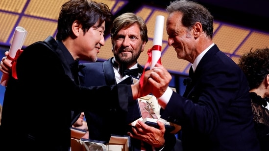 The 75th Cannes Film Festival - Closing ceremony - Cannes, France, May 28, 2022. Song Kang-ho, Best Actor award winner for his role in the film "Broker" (Les bonnes etoiles), director Ruben Ostlund, Palme d'Or award winner for the film film "Triangle of Sadness", and Vincent Lindon, Jury President of the 75th Cannes Film Festival, react on stage. REUTERS/Sarah Meyssonnier TPX IMAGES OF THE DAY(REUTERS)