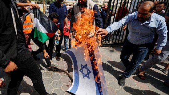 Palestinians burn a representation of an Israeli flag during a protest over tensions in Jerusalem's Al-Aqsa Mosque, in Khan Younis, in the southern Gaza Strip, Sunday.&nbsp;(REUTERS)