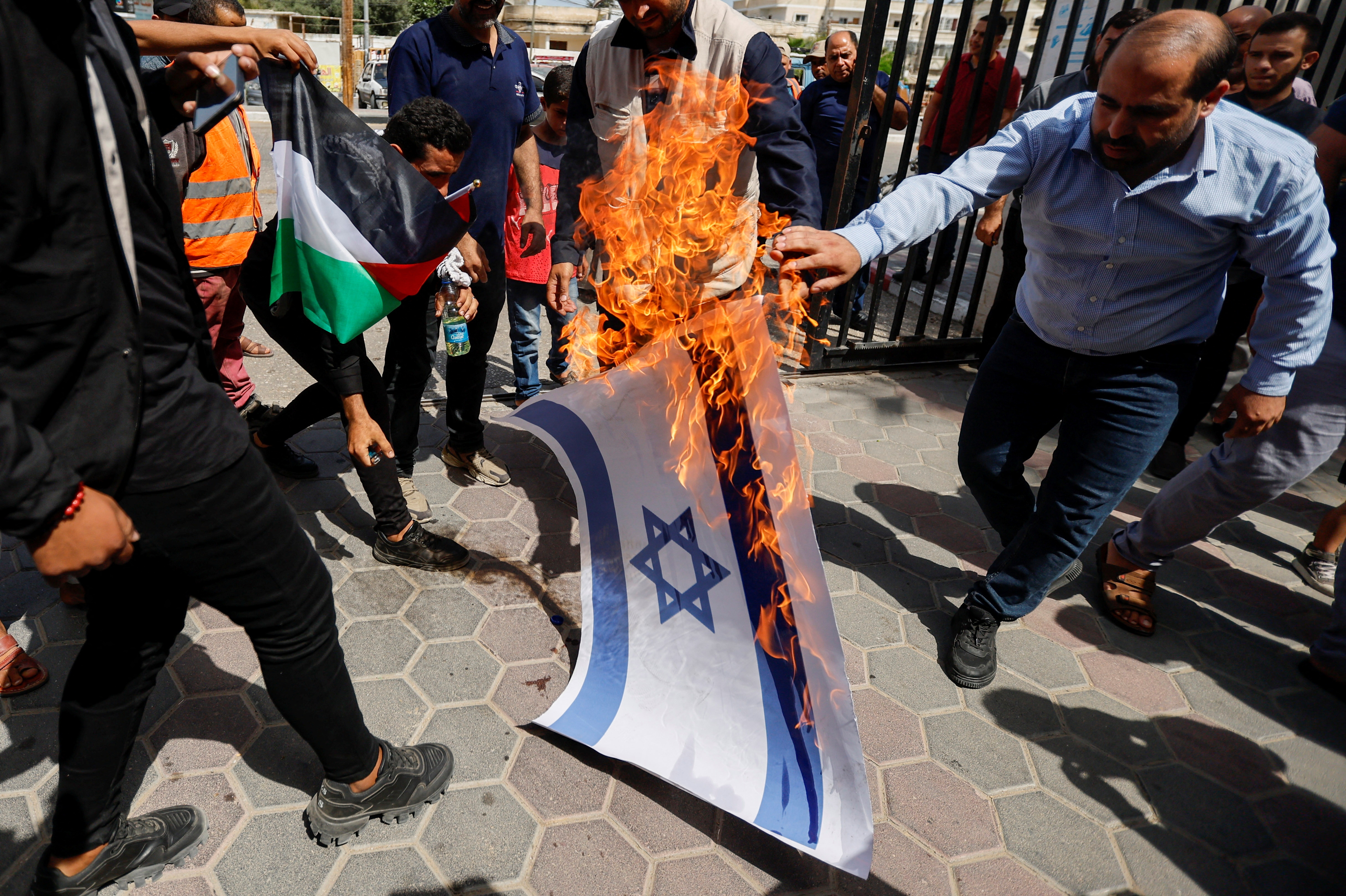 Palestinians burn a representation of an Israeli flag during a protest over tensions in Jerusalem's Al-Aqsa Mosque, in Khan Younis, in the southern Gaza Strip, Sunday.&nbsp; (REUTERS)