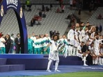 Real Madrid's Marcelo gestures to the fans as he carries the Champions League trophy to the presentation area