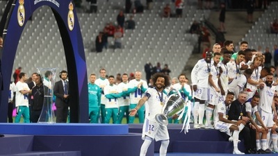 Real Madrid's Marcelo gestures to the fans as he carries the Champions League trophy to the presentation area (REUTERS)
