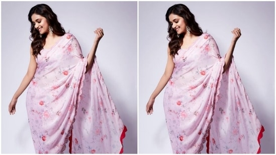 Keerthy decked up in a pastel pink satin saree with minimal floral details and a red border. She teamed it with a sequined pastel pink blouse with a tie-up detail at the back.(Instagram/@keerthysureshofficial)