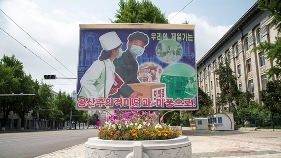 A poster displayed outside Pyongyang showing people wearing face makes and reading "Displaying beautiful communist virtues and traits" is pictured in Pyongyang on May 27.(AFP)