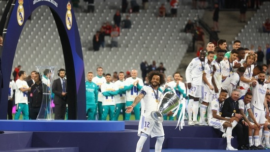 Real Madrid's Marcelo gestures to the fans as he carries the Champions League trophy to the presentation area(REUTERS)