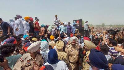 Balkaur Singh, father of Sidhu Moosewala, who was shot dead on Sunday, accepts condolences from supporters and fans of the Punjabi singer during his last rites, in Mansa district on Tuesday. (PTI)