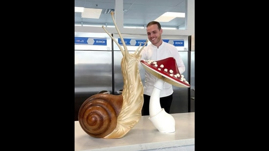 Pastry chef Amaury Guichon with the huge snail and mushroom made out of chocolate.(Instagram/@amauryguichon) Pastry chef Amaury Guichon with the huge snail and mushroom made out of chocolate.(Instagram/@amauryguichon)