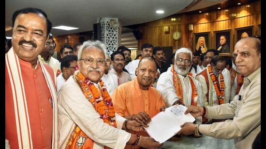 BJP candidate Laxmikant Bajpai files his nomination paper for Rajya Sabha elections, at Vidhan Bhawan, in Lucknow on Tuesday. Uttar Pradesh chief minister Yogi Adityanath, deputy chief minister Keshav Prasad Maurya and BJP state chief Swatantra Dev Singh also seen. (ANI Photo)