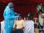 A person takes an RT-PCR test before receiving a dose of the Covid-19 vaccine at a vaccination center.