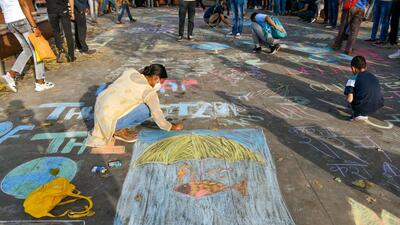 Students participate in drawing chalk graffiti art to make people aware of the climate crisis, at Connaught place in New Delhi. (ANI) Students participate in drawing chalk graffiti art to make people aware of the climate crisis, at Connaught place in New Delhi. (ANI)