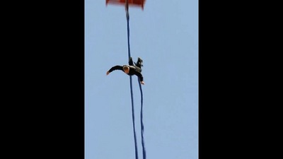 The image, taken from the Guinness World Records video, shows the man bungee jumping to dunk a doughnut into a cup of coffee. (Instagram/@guinnessworldrecords)