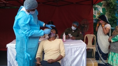 A person takes an RT-PCR test before receiving a dose of the Covid-19 vaccine at a vaccination center. (Bloomberg) A person takes an RT-PCR test before receiving a dose of the Covid-19 vaccine at a vaccination center. (Bloomberg)